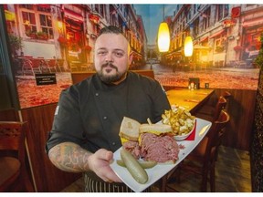 Chef Jay Baker, who grew up in a French-Canadian family, with one of the generous Montreal smoked meat sandwiches with a side of poutine served at Brodeur’s in Abbotsford.