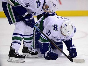 Vancouver Canucks winger Alex Burrows comforts injured centre Brandon Sutter after the latter took a puck to the face during Tuesday’s NHL game against the Colorado Avalanche in Denver. (Ron Chenoy, USA Today)