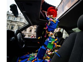 Lego bricks are poured through the sunroof of a BMW 5 series car, used as a receptacle for donations of Lego bricks in the courtyard of the Royal Academy in central London on October 30, 2015. The collection has been organised by Chinese artist and activist Ai Weiwei after Lego refused an order to supply his work.