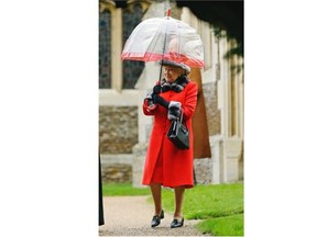 Britain’s Queen Elizabeth II shelters under an umbrella as she leaves, after attending the British royal family’s traditional Christmas Day church service at St. Mary Magdalene Church in Sandringham, England, Friday, Dec. 25, 2015.