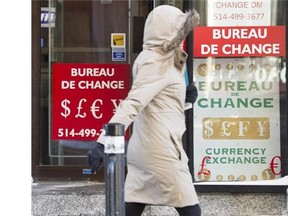 A woman walks past a currency exchange store Wednesday, January 20, 2016 in Montreal. The Canadian dollar came close to falling below 68 cents US in overnight trading amid further pressure on oil prices and uncertainty about what the Bank of Canada will do in response to weakened economic conditions.THE CANADIAN PRESS/Ryan Remiorz