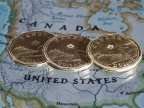 Canadian dollar coins, or Loonies, are displayed on a map of North America in Montreal on January 9, 2014. Realtors who sell Canadian resort properties say the low loonie is spurring interest from American buyers who are looking to pick up cheap vacation homes north of the border."We're thanking our lucky stars," said Brad Hawker from Royal LePage Rocky Mountain Realty in Canmore, Alta. THE CANADIAN PRESS/Paul Chiasson