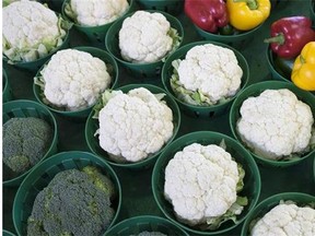 Cauliflowers, surrounded by broccoli and peppers, are seen at the Jean Talon Market, Monday, January 11, 2016 in Montreal. The soaring price of cauliflower is forcing restaurants offering signature dishes featuring the trendy vegetable to rethink menus and raise prices. THE CANADIAN PRESS/Paul Chiasson