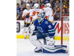 The Calgary Flames celebrate their goal on Vancouver Canucks goalie Ryan Miller in the second period of a regular season NHL hockey game at Rogers Arena, Vancouver, February 06 2016.