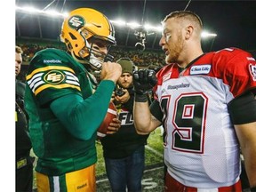 Calgary Stampeders quarterback Bo Levi Mitchell, right, and Edmonton Eskimos quarterback Mike Reilly embrace following the CFL West Division final in Edmonton, Sunday, Nov. 22, 2015.