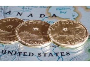 Canadian dollar coins are displayed on a map of North America. A new report by the former chief economic analyst for Statistics Canada is contradicting conventional wisdom about the impact of loonie fluctuations on the economy.