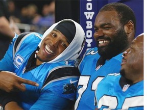 Carolina Panthers quarterback Cam Newton (left) jokes with his offensive tackle Michael Oher and with Mike Tolbert (far right) during a 33-14 win against the Dallas Cowboys at AT&T Stadium on Nov. 26, 2015 in Arlington, Texas.