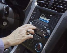 An industry affiliate tests out Ford's SYNC connection and entertainment system inside a Ford Fusion at the Consumer Electronics Show, Wednesday, Jan. 9, 2013, in Las Vegas. The family car is learning more about who's behind the wheel ??? everything from where a driver likes to shop to how hard they brake ??? as automakers roll out new tech-savvy features. THE CANADIAN PRESS/AP/Julie Jacobson