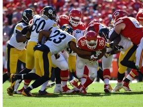 Charcandrick West #35 of the Kansas City Chiefs is tackled by Mike Mitchell #23 of the Pittsburgh Steelers at Arrowhead Stadium during the second quarter of the game on October 25, 2015 in Kansas City, Missouri.