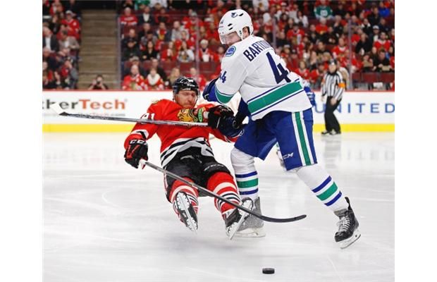 Chicago Blackhawks right wing Marian Hossa (81) and Vancouver Canucks defenseman Matt Bartkowski (44) collide during the second period of an NHL hockey game in Chicago, Sunday, Dec. 13, 2015.