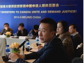 Chinese investor applicant Du Jun, centre, talks about his faith next to other investors during a press conference in Beijing in March to protest the Canadian government decision to ditch its backlogged investor immigrant program and eliminate thousands of applications from Chinese nationals.