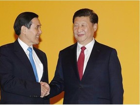 Chinese President Xi Jinping, right, and Taiwanese President Ma Ying-jeou, left, shake hands at the Shangri-la Hotel on Saturday, Nov. 7, 2015, in Singapore. The two leaders shook hands at the start of a historic meeting, marking the first top level contact between the formerly bitter Cold War foes since they split amid civil war 66 years ago.