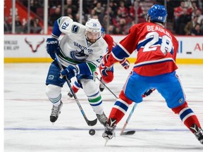 Chris Higgins #20 of the Vancouver Canucks skates with the puck near Nathan Beaulieu #28 of the Montreal Canadiens during the NHL game at the Bell Centre on November 16, 2015 in Montreal, Quebec, Canada.