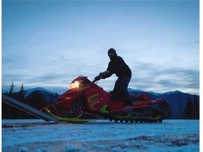 Clint Pelletier, of Edmonton, loads his snowmobile onto a trailer after snowmobiling with his wife at Mount Renshaw near McBride on Saturday. Five snowmobilers died Friday in a major avalanche in the Renshaw area.