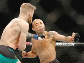 Conor McGregor, left, fights Jose Aldo during a featherweight championship mixed martial arts bout at UFC 194, Saturday, Dec. 12, 2015, in Las Vegas. McGregor stopped Aldo with one spectacular punch just 13 seconds into the first round Saturday night, backing up his bravado and claiming the undisputed featherweight title at UFC 194 on Saturday night.