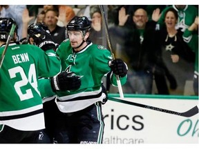 Dallas Stars left wing Patrick Sharp (10) celebrates scoring his goal with teammates Jordie Benn (24) and Jason Spezza (90) during the first period of an NHL hockey game against the Vancouver Canucks Thursday, Oct. 29, 2015, in Dallas.