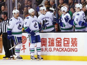 Daniel Sedin #22 of the Vancouver Canucks celebrates with Chris Tanev #8 and teammates after scoring against the Boston Bruins  during the third period at TD Garden on January 21, 2016 in Boston, Massachusetts. The Canucks defeat the Bruins 4-2.