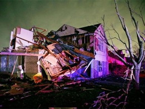 Debris lies on the ground near a home that was heavily damaged by a tornado in Rowlett, Texas, Saturday, Dec. 26, 2015. Tornadoes swept through the Dallas area after dark on Saturday evening causing significant damage.