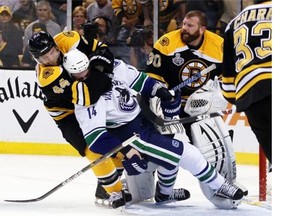 Dennis Seidenberg #44 of the Boston Bruins  tackles Alex Burrows #14 of the Vancouver Canucks after an incident with Tim Thomas #30 of the Boston Bruins during Game Four of the 2011 NHL Stanley Cup Final at TD Garden on June 8, 2011 in Boston, Massachusetts.