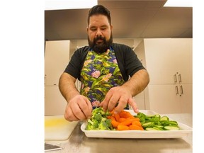 Dustin Thorkelsson, a teacher at West Coast Alternate School, works in the kitchen during the Wednesday lunch program.