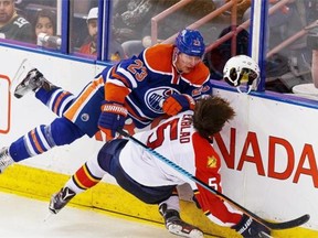 Edmonton Oilers forward Matt Hendricks (top) crashes into Florida Panthers defenceman Aaron Ekblad during the third period of their NHL game at Rexall Place in Edmonton on Sunday, Jan. 10, 2016.