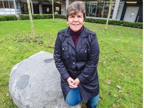 Elder-in-residence Gail Sparrow with the historically significant rock that has been moved from Musqueam territory to Langara in Vancouver.