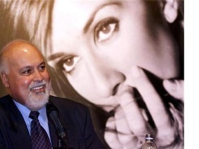Rene Angelil respnds to a question with a giant photgraph of his wife singer Celine Dion in the background during a news conference in Montreal Wednesday, Sept. 8, 1999. This is the first public appearance for Angelil since undergoing cancer treatments. Angelil, the entertainment maestro who guided Dion to superstardom and then married her, has died, according to Francine Chaloult, a spokeswoman for Dion. THE CANADIAN PRESS/Paul Chiasson