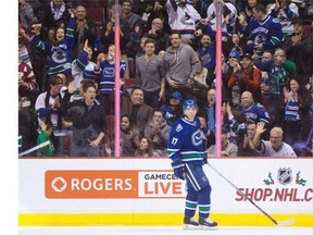 Fans celebrate a goal by Vancouver Canucks’ Radim Vrbata, of the Czech Republic, as he looks up at the replay during the first period of an NHL hockey game against the Buffalo Sabres in Vancouver, B.C., on Monday December 7, 2015.