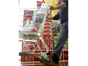 File: A shopper passes cartons of Coca-Cola in a grocery June 13, 2006 in Des Plaines, Illinois. Doctors at the annual American Medical Association meeting in Chicago this week have called for a “fat tax” on sugary soft drinks to help fight obesity in the U.S.
