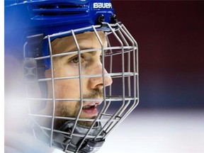 File: Vancouver Canucks’ defenceman Dan Hamhuis, who was injured after being struck in the face by a puck during a game in December, wears a cage on his helmet during NHL hockey practice in Vancouver, B.C., on Monday, January 25, 2016.