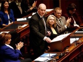 B.C. Finance Minister Michael de Jong, centre, tables a balanced budget for a fourth year in a row at the Legislative Assembly in Victoria on Tuesday.