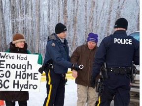 Fort St. John RCMP arrest Arthur Hadland for mischief during a Site C protest Wednesday as fellow activist Penny Boden looks on. Photo by Bronwyn Scott/Alaska Highway News.