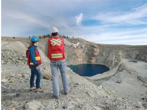 Geologist Renee Potvin and environmental scientist Rob Maciak looking over the site of KGHM International’s proposed Ajax copper and gold mine. The pit in the photograph is pre-existing from a past mining operation.