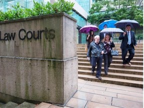 Ivan Henry, front left, who was wrongfully convicted of sexual assault in 1983, and his daughter Tanya Olivares leave B.C. Supreme Court in Vancouver earlier in the trial in which he is seeking compensation.