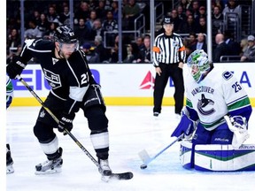 Jacob Markstrom #25 of the Vancouver Canucks makes a save as Alec Martinez #27 of the Los Angeles Kings goes for a rebound during the second period at Staples Center on December 1, 2015 in Los Angeles, California.