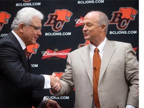 Jeff Tedford, right, shakes hands with general manager Wally Buono upon becoming the Lions head coach a year ago.