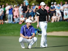 Jordan Spieth of the United States (left) and Rory McIlroy of Northern Ireland and wait for their turn on the first green during the second round of the Abu Dhabi HSBC Golf Championship in Abu Dhabi, United Arab Emirates, on Friday, Jan. 22, 2016.