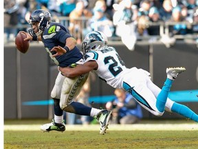 Josh Norman #24 of the Carolina Panthers sacks  Russell Wilson #3 of the Seattle Seahawks in the 2nd half during the NFC Divisional Playoff Game at Bank of America Stadium on January 17, 2016 in Charlotte, North Carolina.