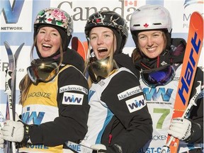 Moguls winner Justine Dufour-Lapointe is flanked on the podium by her sisters, second place Chloe, left, and third place Maxime, right, at the FIS Freestyle Ski World Cup Saturday in Val St-Come, Que.