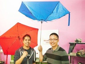 Kevin Truong, left, and Cahay Ho are developers of the Cypress Umbrella (red umbrella on left), which unlike the blue umbrella, has an automotive-inspired suspension system to withstand crazy winds.