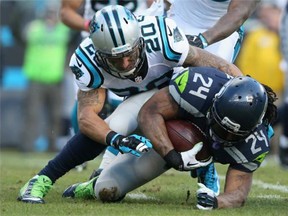 Kurt Coleman #20 of the Carolina Panthers tackles  Marshawn Lynch #24 of the Seattle Seahawks in the 2nd quarter during the NFC Divisional Playoff Game at Bank of America Stadium on January 17, 2016 in Charlotte, North Carolina.