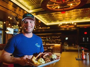 Mark Crofton, executive chef and pit master, poses with a dish of barbecue at the re-opened Yale in Vancouver.