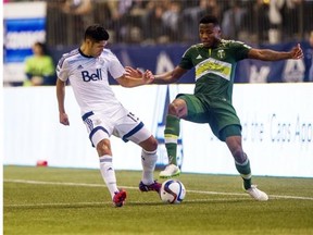 Matias Laba #15 of the Vancouver Whitecaps FC battles with Alvas Powell #2 of the Portland Timbers for the ball in MLS action on March, 28, 2015 at BC Place Stadium in Vancouver, British Columbia, Canada.