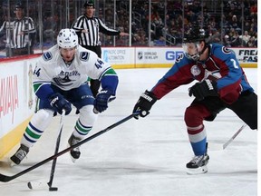 Matt Bartkowski #44 of the Vancouver Canucks controls the puck against the defense of Nick Holden #2 of the Colorado Avalanche at Pepsi Center on February 9, 2016 in Denver, Colorado.