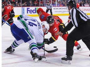 Matt Stajan #18 of the Calgary Flames faces-off against Adam Cracknell #24 of the Vancouver Canucks during an NHL game at Scotiabank Saddledome on February 19, 2016 in Calgary, Alberta, Canada.