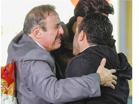 Mohamad Alhomsi, left, is overcome with emotion as he embraces his two sons Majd, 22, front, and Yaseen, 25, at Vancouver International Airport on Thursday.