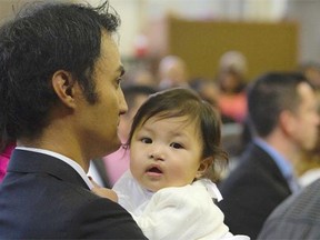 Neptali De Rama with his daughter Emily at her baptism in Ontario.