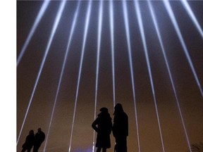 MONTREAL, QUE.: DECEMBER 6, 2014 --  A couple stands in silhouette against some of the 14 beams of light pointing skywards at the Mont Royal Chalet in Montreal, Saturday December 6, 2014.  It was part of a day of commemorations to mark the 25th anniversary of the murder of 14 women at the École Polytechnique, by Marc Lépine.  (Phil Carpenter / MONTREAL GAZETTE)