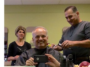 Coquitlam Mayor Richard Stewart takes a selfie Wednesday morning, Jan. 6, 2016 as he gets his hair cut by Syrian immigrant Mohammed Kurdi, the uncle of Alan Kurdi who drowned and washed up on the Turkish beach. It was Kurdi's first time cutting someone's hair in Canada and symbolic of his new start with his family after so much turmoil. At left is Tima Kurdi.