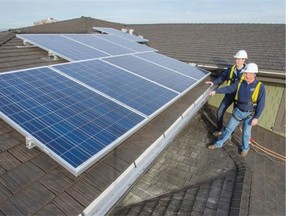 Ken Mayhew (front) is owner and president of Penfolds Roofing and Solar. He inspects a solar panel installation with his son and marketing and sales manager, Shaun Mayhew, at a home in Tsawwassen. Penfolds collaborated with Vancouver Renewable Energy Cooperative which designed and installed the solar panel system.